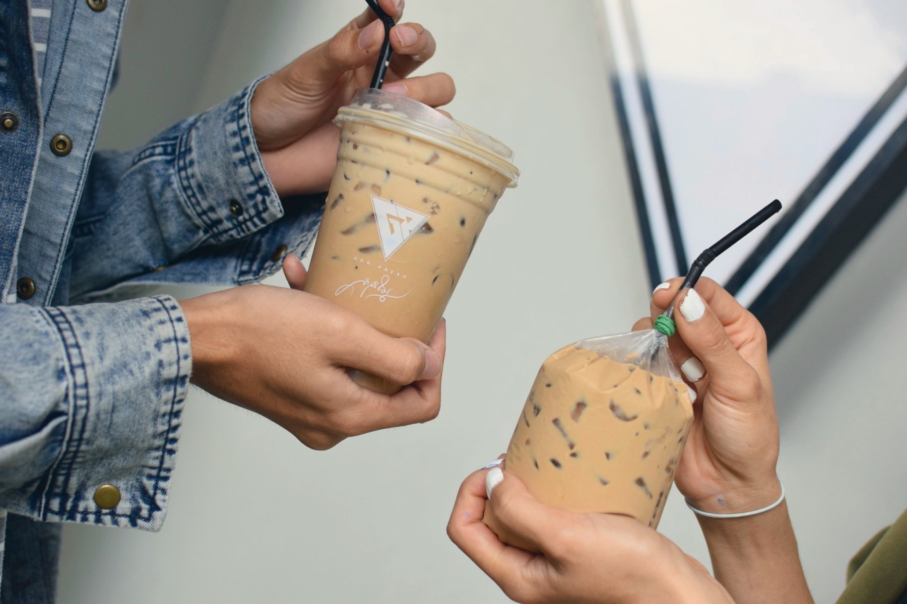 Two iced coffees from GP Cafe held up together