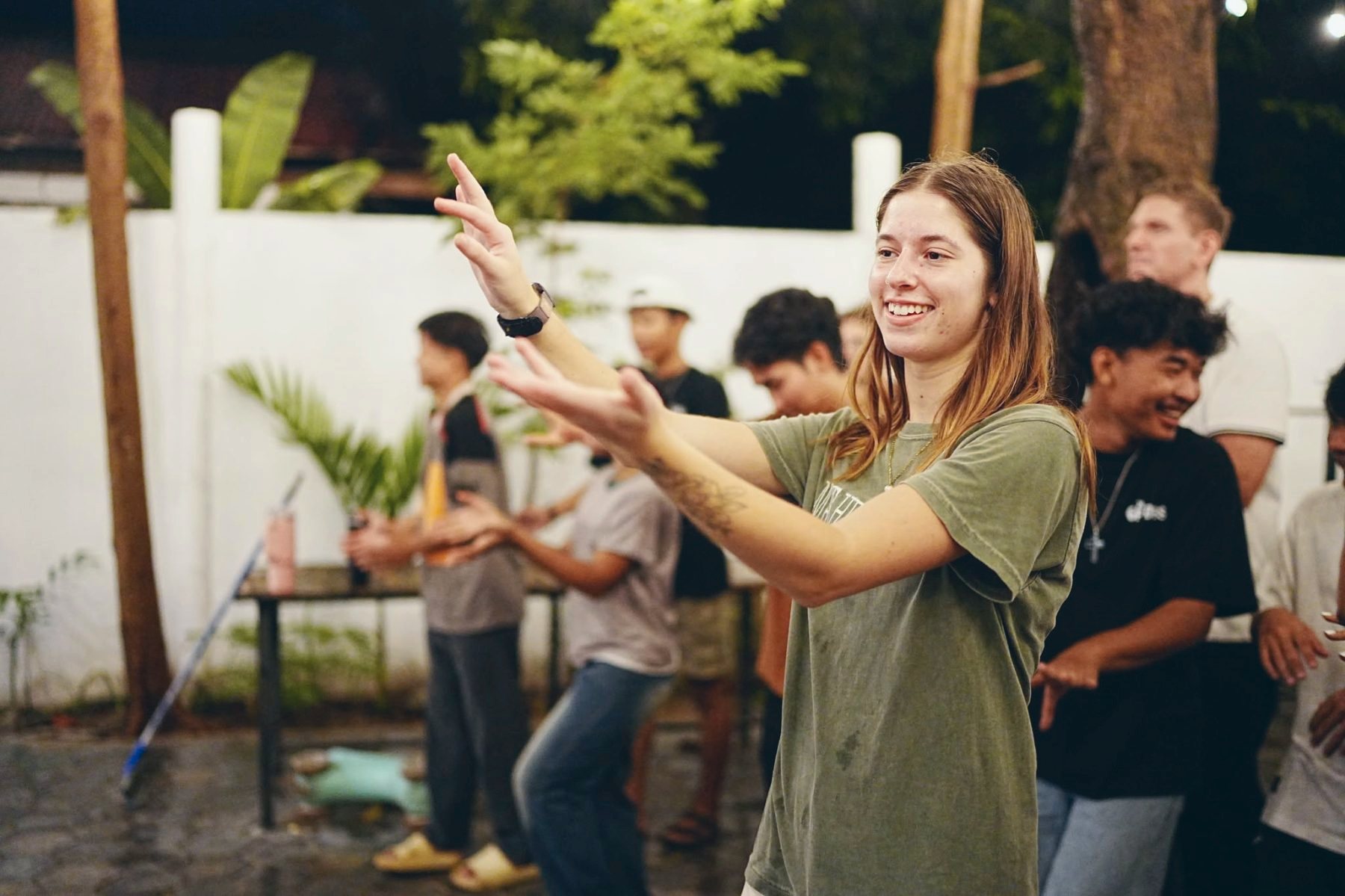 Students leading actions together in the courtyard at night