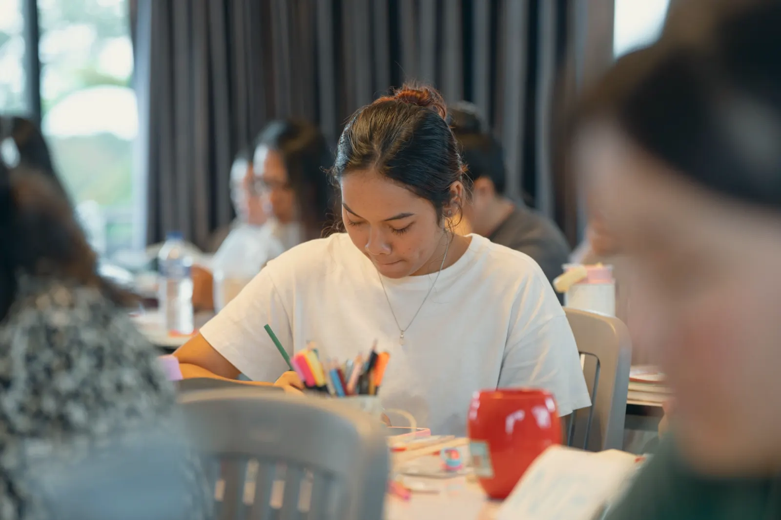 A student writing in her notebook during a BCS session