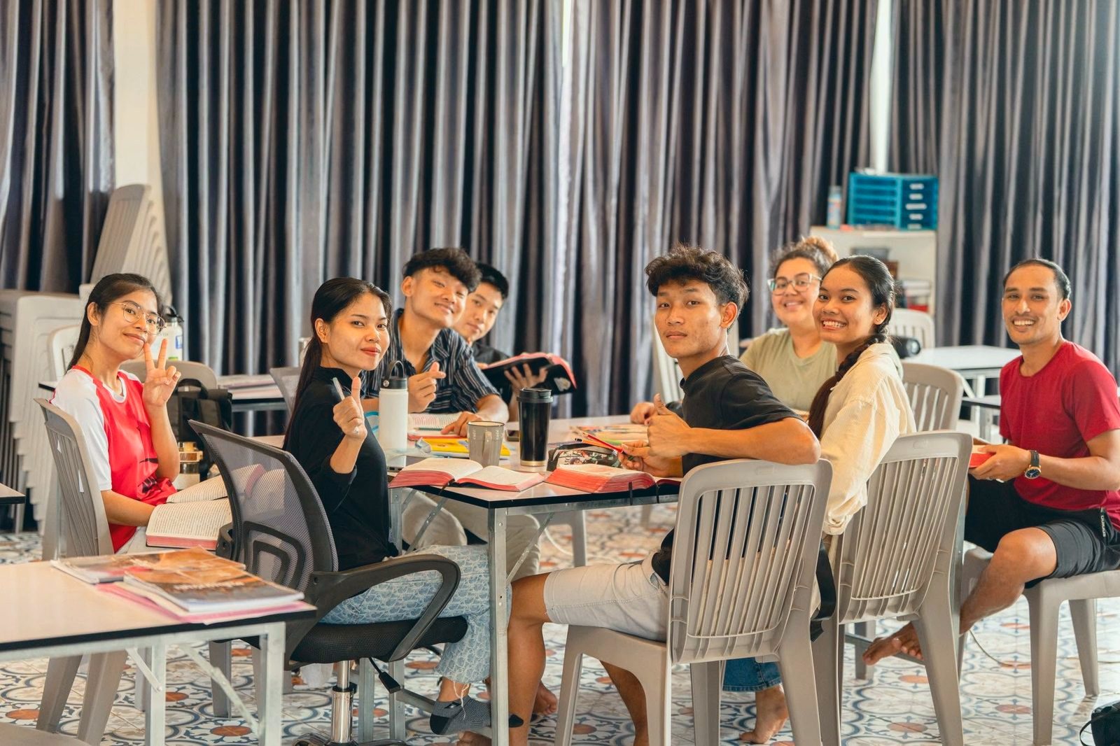 Students at their desks in class, turning to smile at the camera