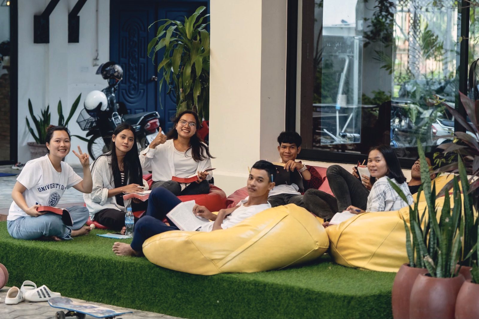 Students reading together on bean bags in a bright lounge