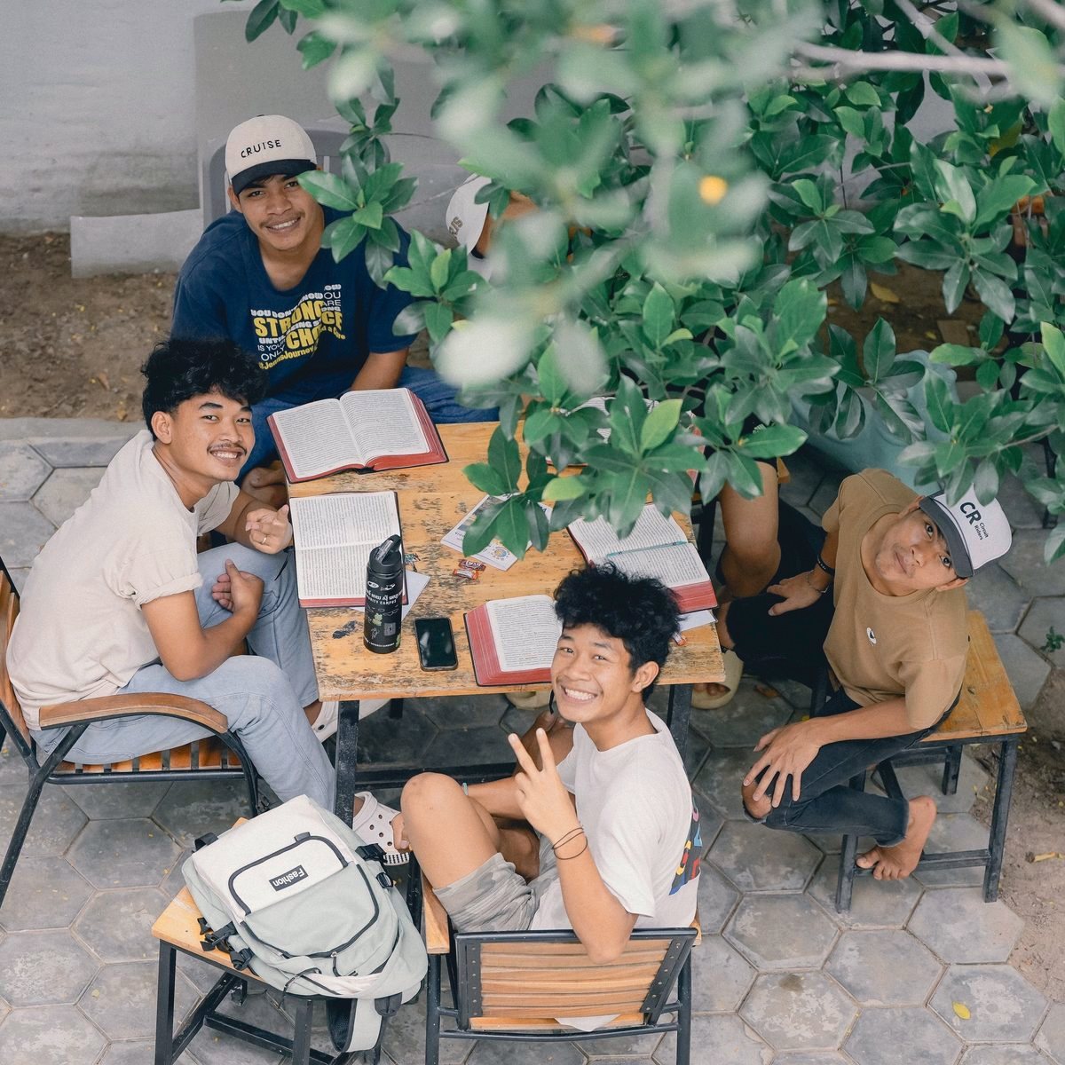 Students studying together around a table under a tree on the Siem Reap campus