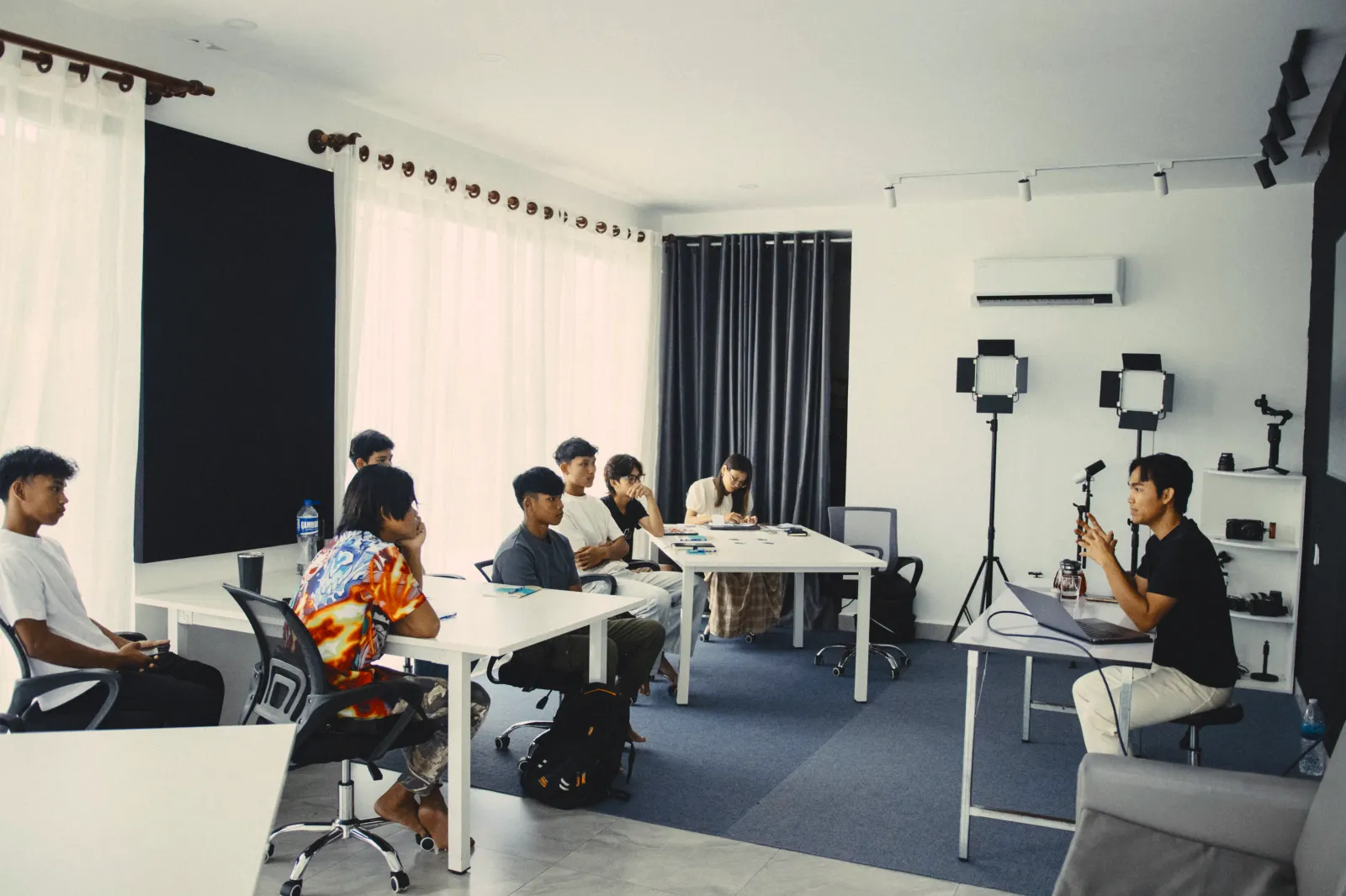 A media class in the studio, students at white desks listening to the teacher
